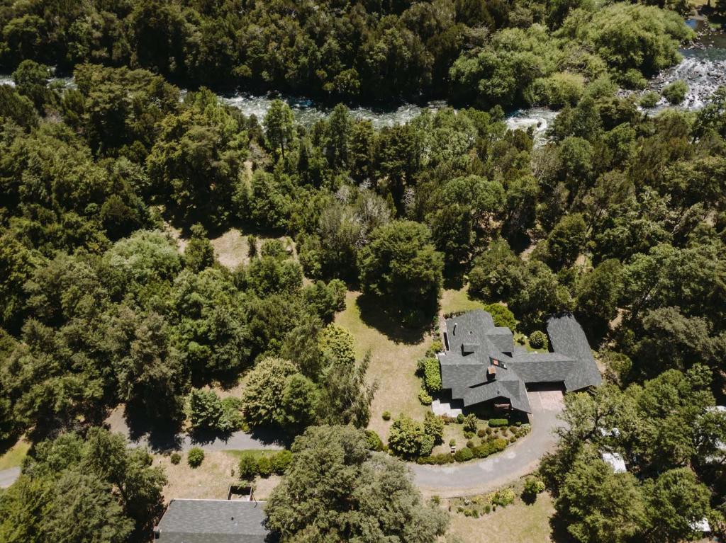 uma vista aérea de uma casa na floresta em Hotel Posada del Río - Parque Metreñehue em Pucón