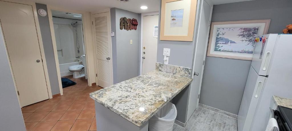 a kitchen with a granite counter top and a refrigerator at Gulfview II #604 in South Padre Island