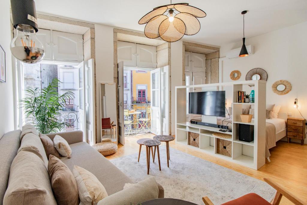 - un salon avec un canapé et une télévision dans l'établissement Virtudes Flat w/ AC & Balcony by LovelyStay, à Porto