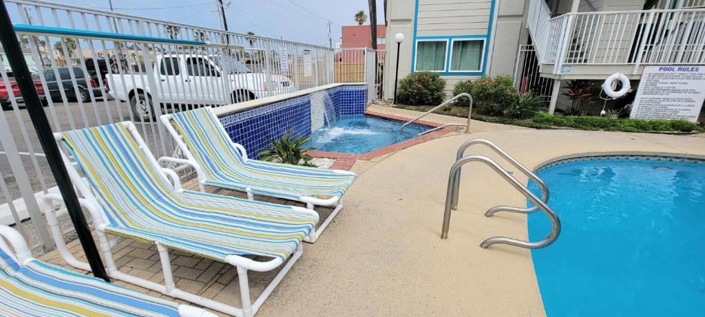 - deux chaises assises à côté de la piscine dans l'établissement La Internacional 313, à South Padre Island