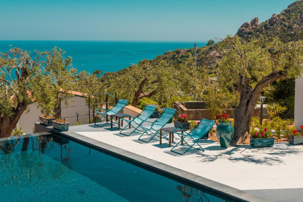 una piscina con sillas y el océano en el fondo en Villa Totò Resort, en Cefalú