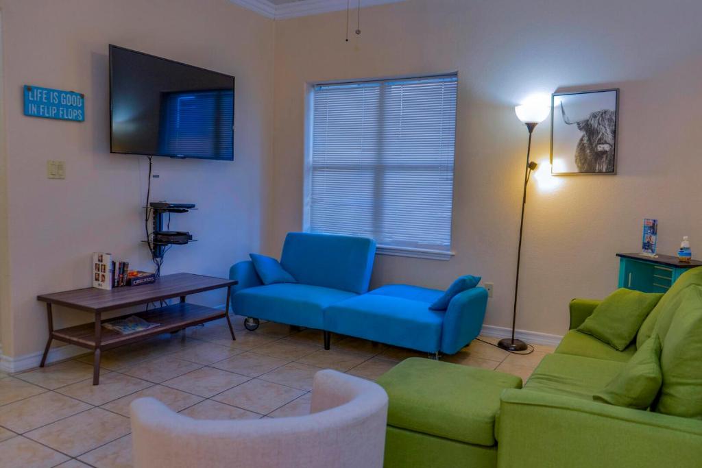 a living room with a blue couch and a tv at Clean Pool Walk to Beach - Pet Ok - Ground Floor in South Padre Island