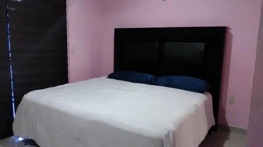 1 dormitorio con cama blanca y cabecero negro en Hermosa casa Villa de la Abuela en Tampico, en Tampico