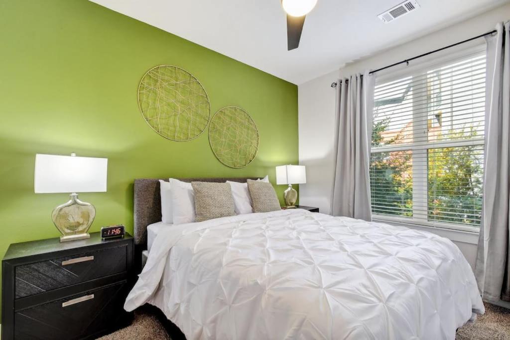 - une chambre avec un lit blanc et un mur vert dans l'établissement Relaxing Apartment Southtown, à San Antonio