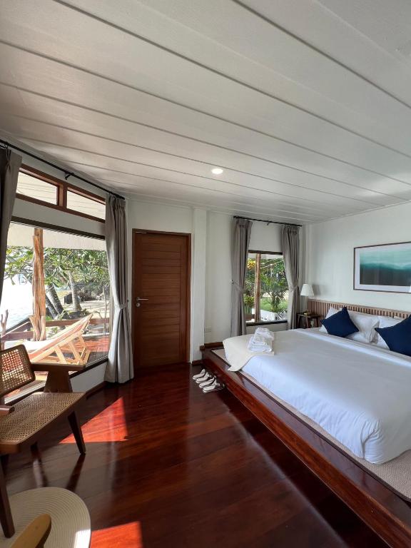 a large bedroom with a large bed and a table at Boon Heritage House Koh Samui in Koh Samui