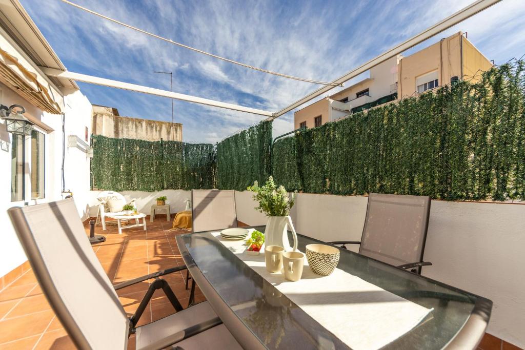 een patio met een tafel en stoelen en een hek bij WOOOW!!! Àtic Cèntric amb Terrassa in Tarragona