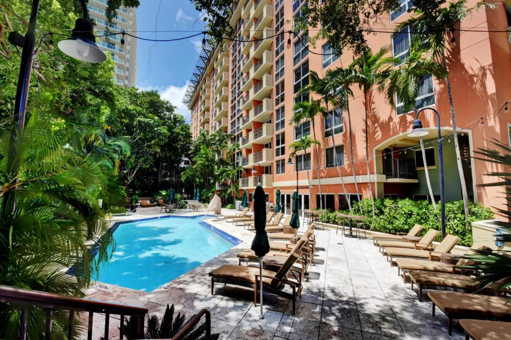 une piscine avec des chaises et un bâtiment dans l'établissement The Mutiny Luxury Suites Hotel, à Miami