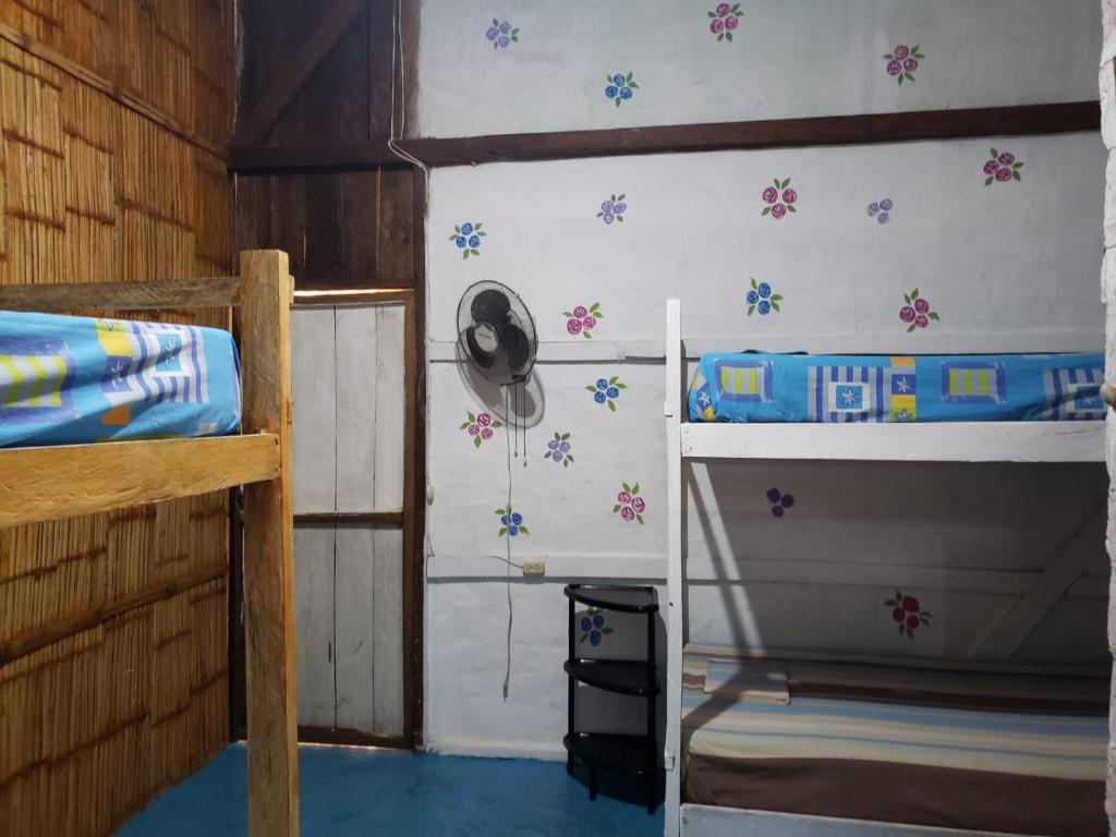 a room with two bunk beds and a fan at Casa surf arrels in Montañita