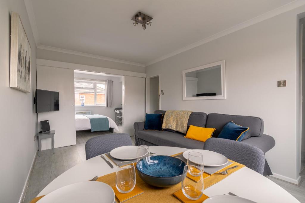 a living room with a table and a couch at Racecourse Revelation! Free parking in Newbury