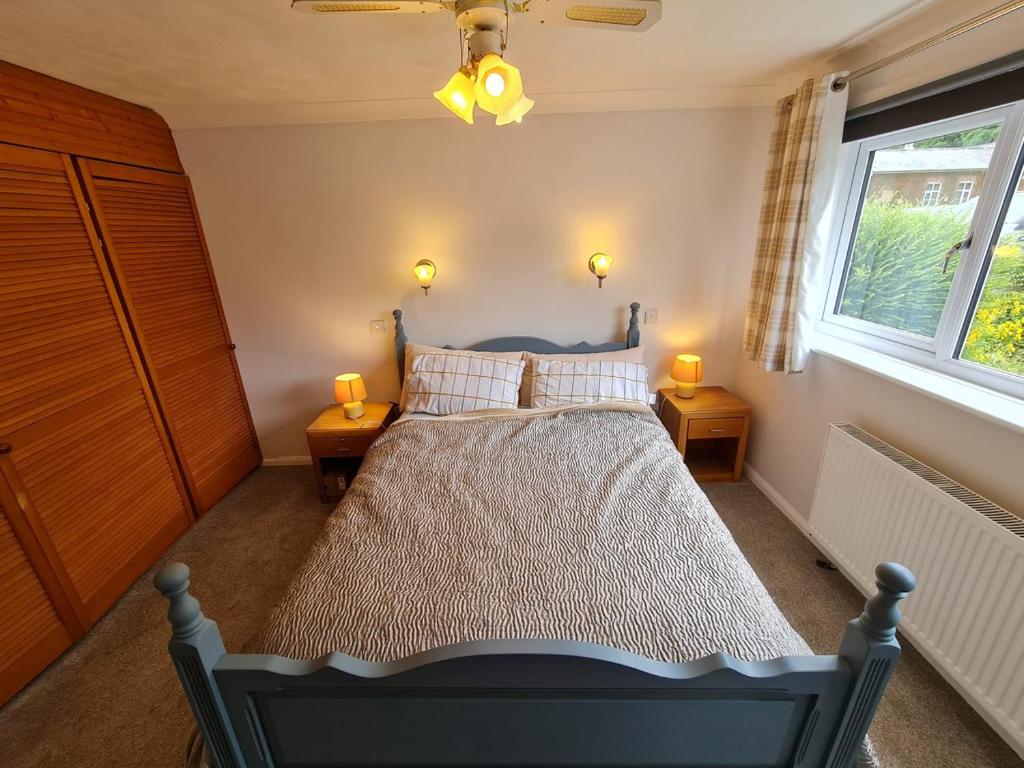 a bedroom with a bed with two lamps on two tables at Rycroft in North Runcton