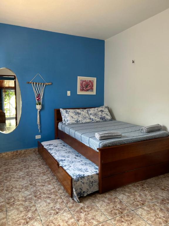 1 dormitorio con cama y pared azul en Flat Meier, en Canoa Quebrada