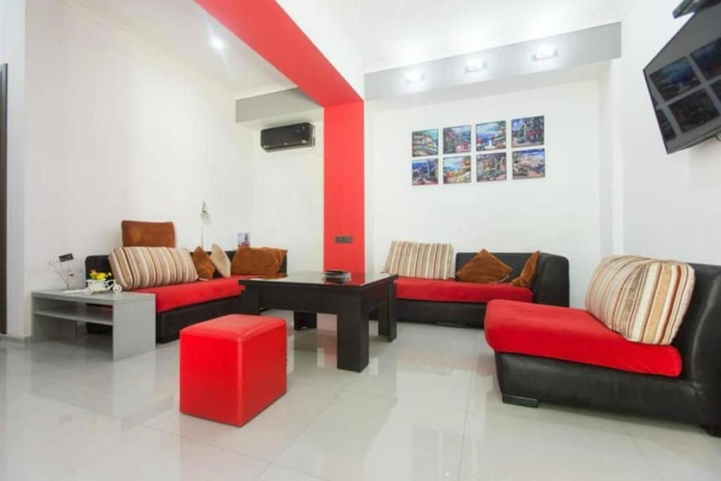 una sala de estar con sofás rojos y negros y una mesa. en Apartments Lezzet, en Tiflis