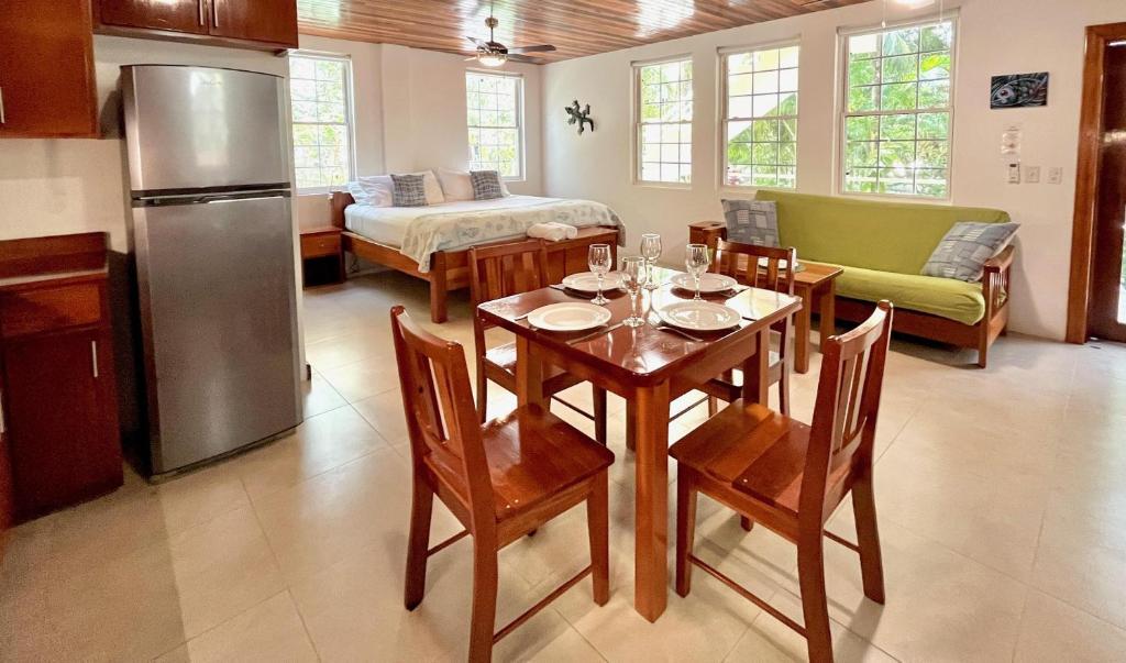 a kitchen and dining room with a table and a refrigerator at Caribbean Beach Suite in Caye Caulker