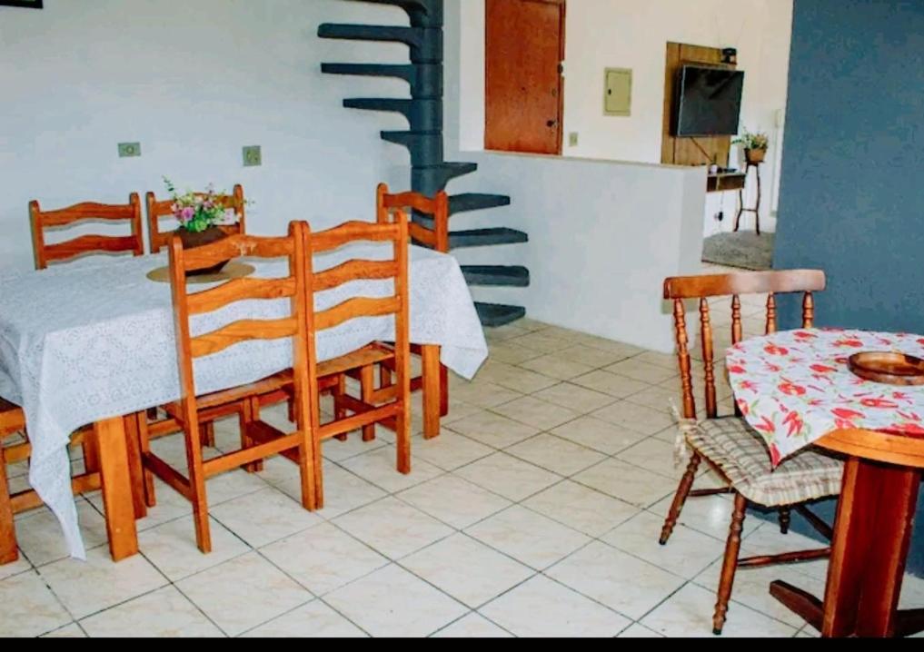 a kitchen and dining room with a table and chairs at Excelente Apto a 2 km CENTRINHO TURÍSTICO in Campos do Jordão