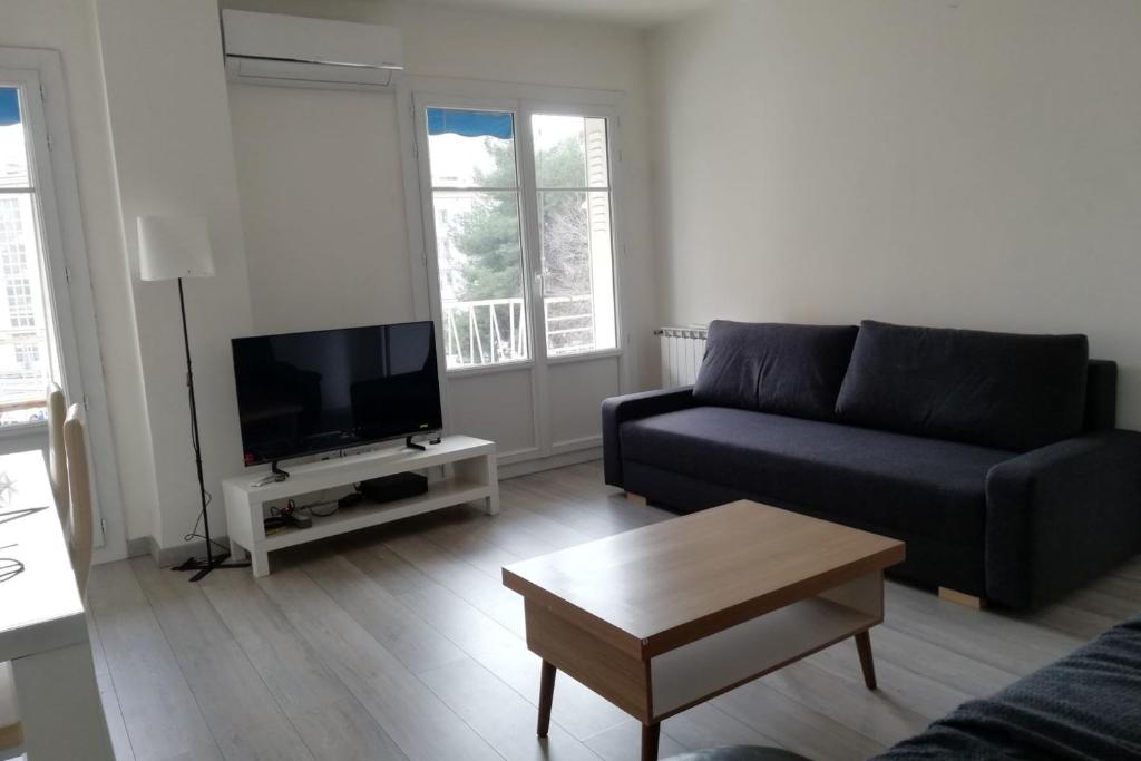un salon avec un canapé et une télévision dans l'établissement 65m with small balcony - near naval base, à Toulon