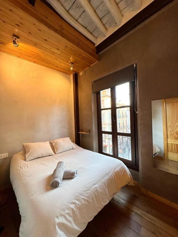 Schlafzimmer mit einem großen weißen Bett und einem Fenster in der Unterkunft Suite Catedral in Granada