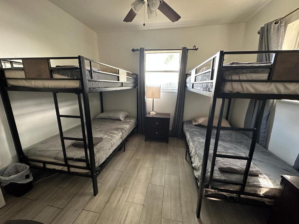 a room with two bunk beds and a ceiling fan at Bekahouse Hostel with parking, backyard and laundry in Miami