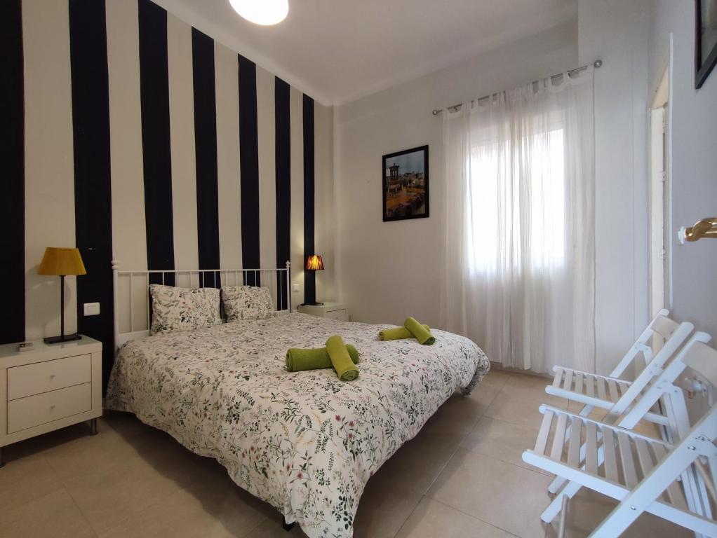 1 dormitorio con 1 cama con 2 almohadas verdes en Manuel Agustín Heredia, en Málaga