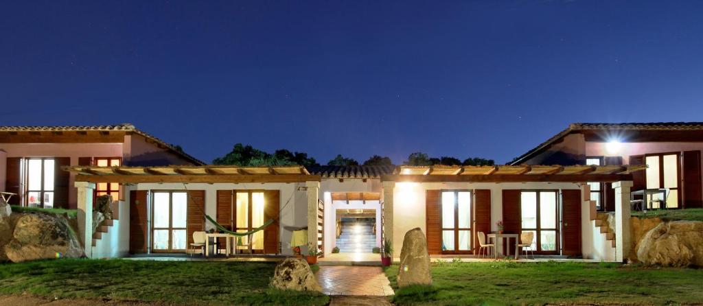 una casa con un fronte illuminato di notte di Sardinia Green Park Country Lodge a Olbia