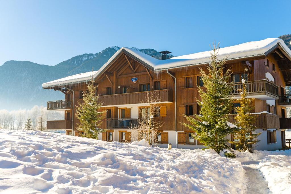 un lodge dans la neige recouverte de neige dans l'établissement Lagrange Vacances Les Fermes de Samoëns, à Samoëns