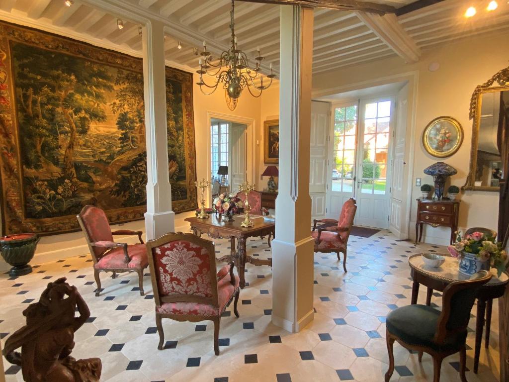 a dining room with a large painting on the wall at Château de Bouesse en Berry in Bouesse