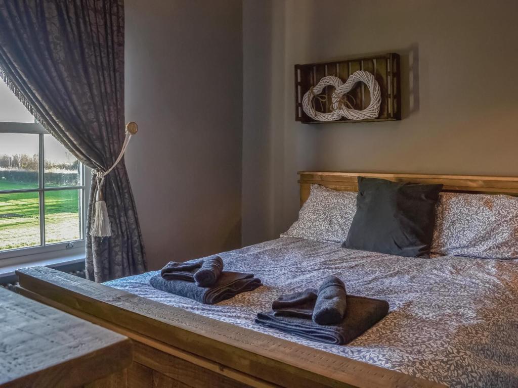 a bed with towels on top of it with a window at Loyal Cerise Bondgate in Selby