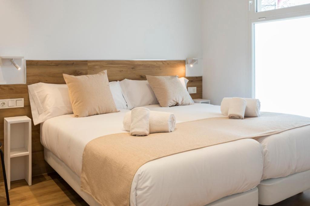a bedroom with a large bed with white sheets and pillows at Elegant Rooms Lasarte in Lasarte