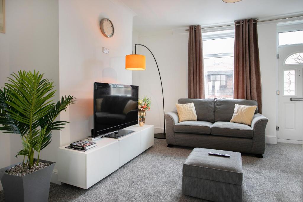 sala de estar con TV y sofá en Cudworth House, Barnsley for contractors, families & Biz, en Barnsley