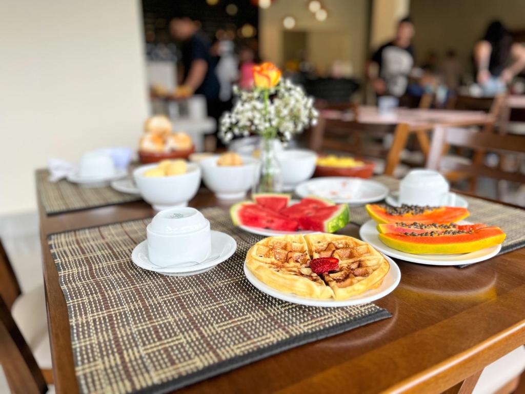 una mesa de madera con platos de comida. en Pousadinha Campos, en Campos do Jordão