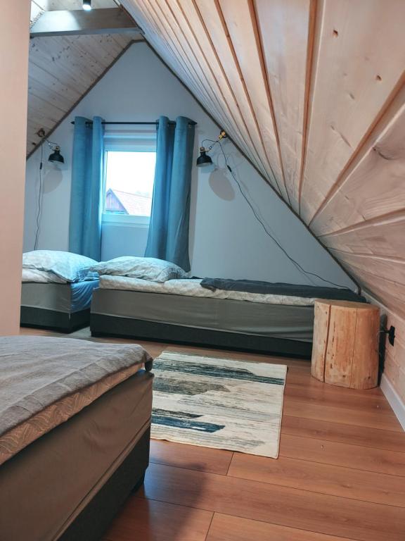 2 Betten in einem Zimmer mit Fenster in der Unterkunft Leśny Reset in Mrągowo