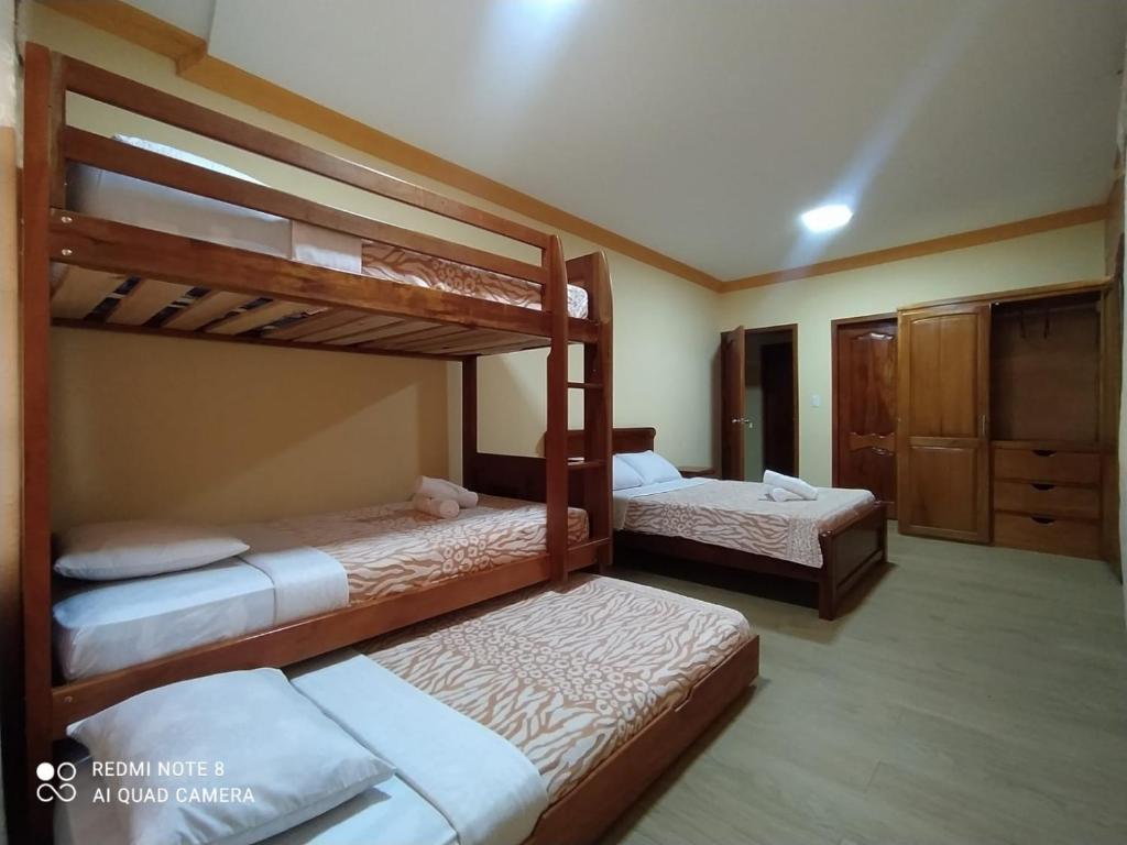 a bedroom with two bunk beds and a closet at Hostal El Eden de Mindo in Mindo
