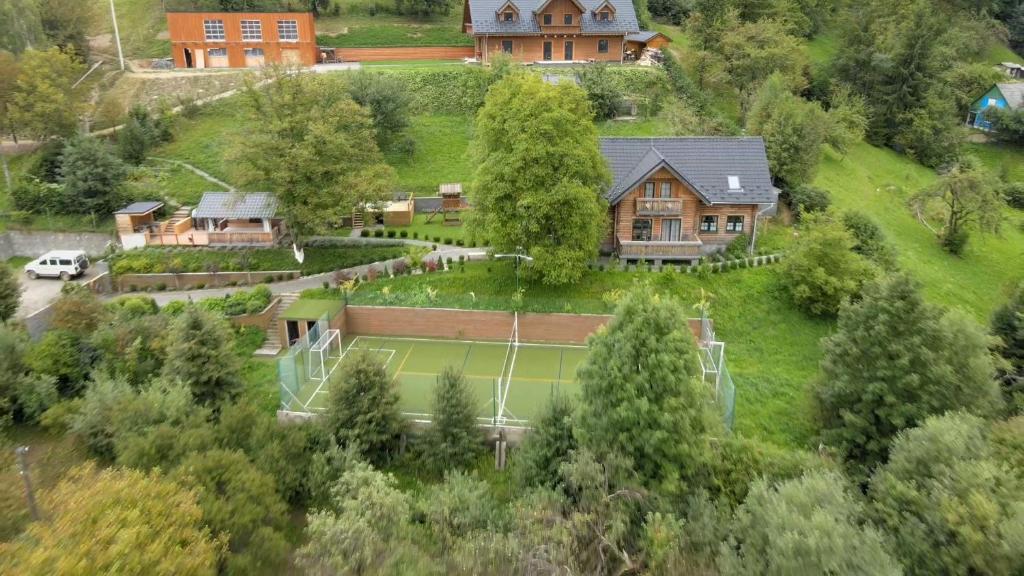 ein Haus auf einem Hügel mit einem Tennisplatz in der Unterkunft Rakhiv House in Rachiw
