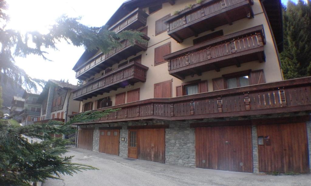 un gran edificio con puertas de madera y valla en Casa di Giulia en Champoluc