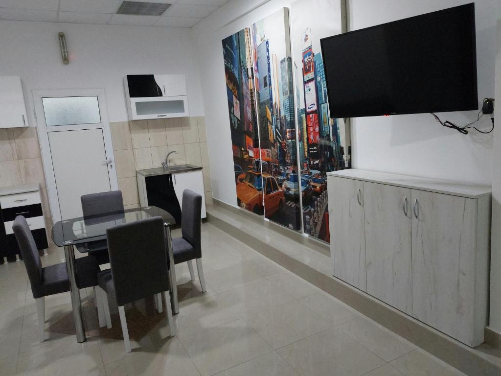 uma sala de jantar com uma mesa e uma televisão de ecrã plano em Apartman Aleksić u samom centru grada em Knjazevac.