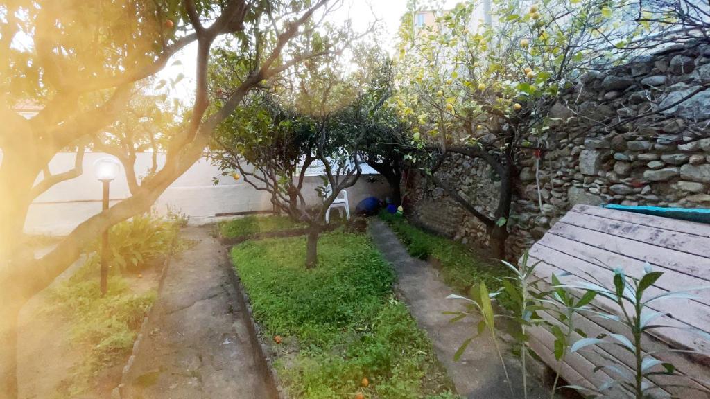 un giardino con panchina e muro di pietra di IN VILLA Relax a 200 metri da mare e centro a Loano