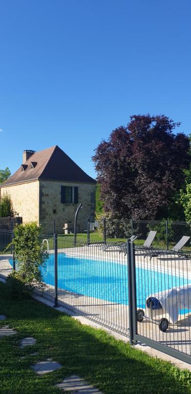 einen Zaun vor einem Pool in der Unterkunft GITE AU ROC DE BOURZAC AVEC PISCINE PRIVÉE in Bayac