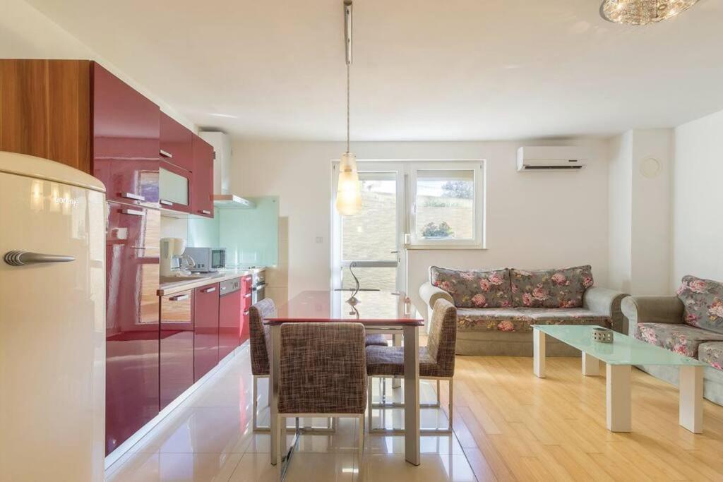 a kitchen and living room with a table and a couch at Vita Garden Apartment 85 m2 Private Entrance & 100 m2 Terrace in Pula