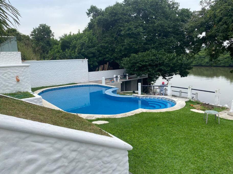 una piscina en un patio junto a un cuerpo de agua en Villa súper ubicada, boca del Río, vista al rio., en Veracruz