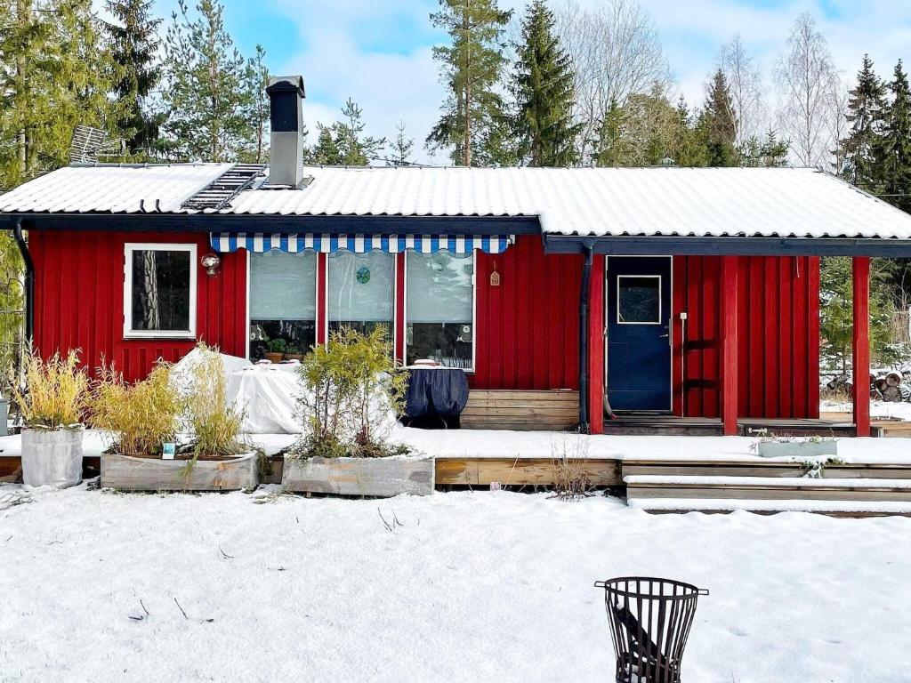 Furusund的住宿－Holiday home BLIDÖ VIII，雪中带蓝色门的红色房子