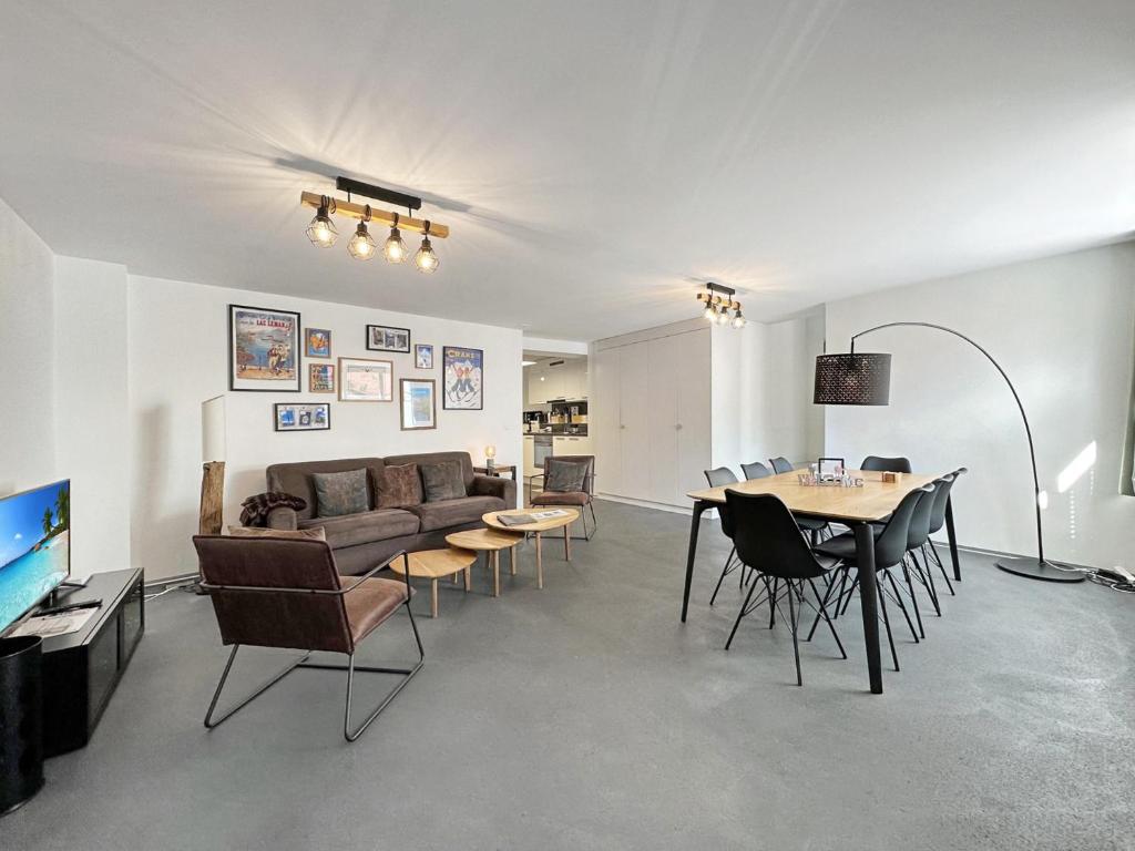 a living room with a couch and a table and chairs at Plein Coeur de la Vieille Ville de Sion in Sion