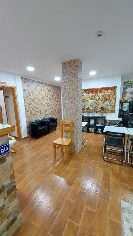 a living room with wooden floors and a table and chairs at Residencial Condado in Faro