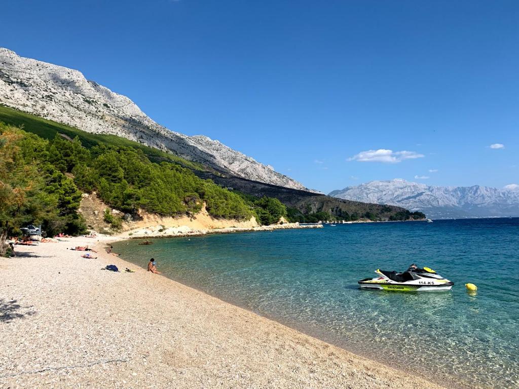 - une plage avec un bateau dans l'eau dans l'établissement Apartment Helios 1, à Lokva Rogoznica