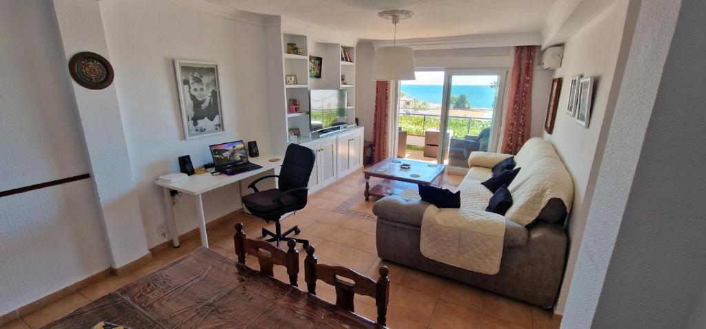 a living room with a couch and a table and a desk at PLAYA RINCON De LA VICTORIA in Rincón de la Victoria