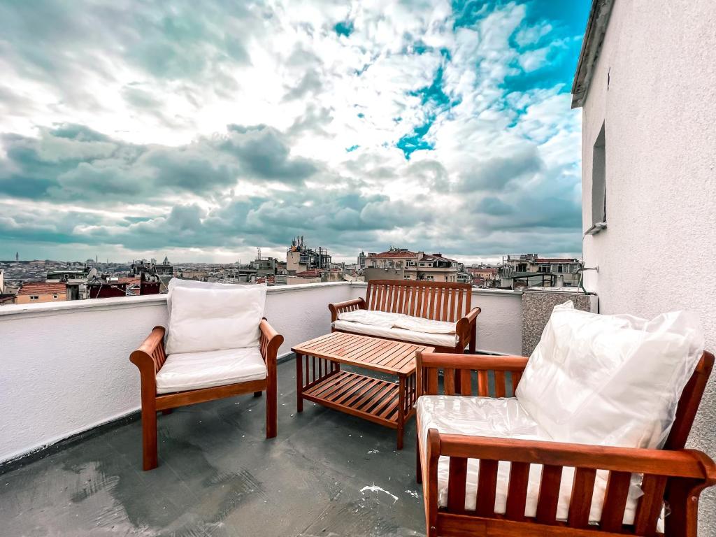 three chairs and a table on a balcony with a view at Cihangir VAV Suites in Istanbul