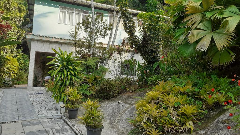 um edifício com um monte de plantas em frente dele em Apartamento em Chácara Aconchegante em Angra dos Reis