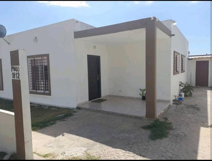 una casa blanca con una puerta en un patio en Aves Del Sol en San Vicente