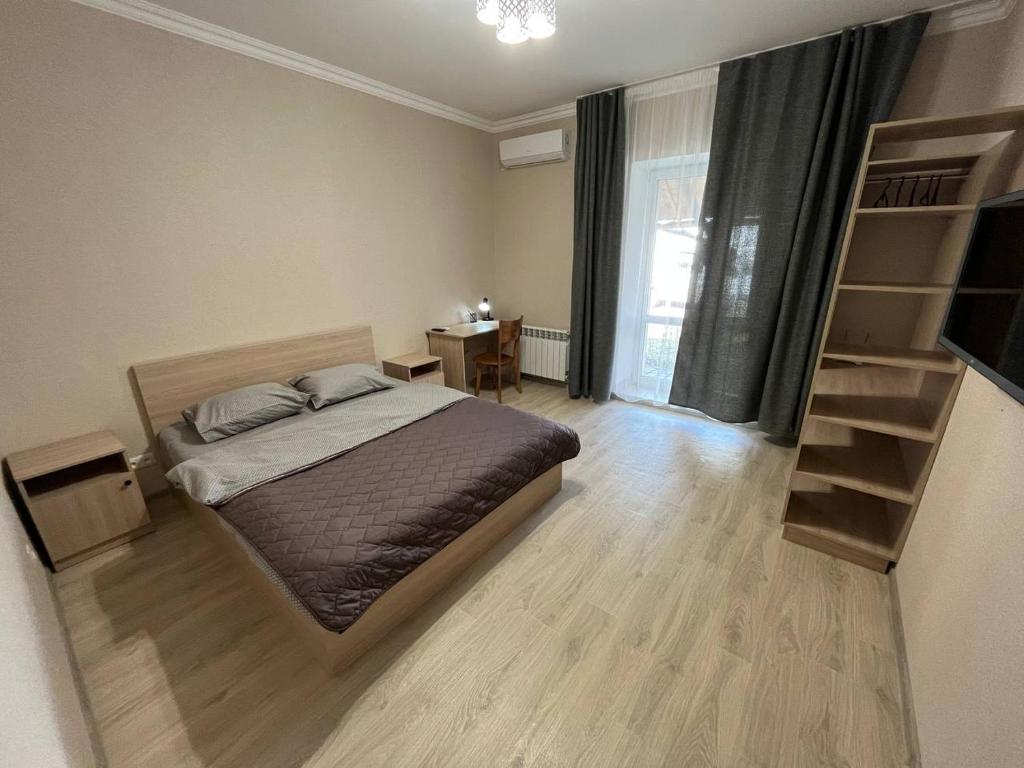 um quarto com uma cama, uma secretária e uma janela em FOX Rooms 90 em Mykolaiv