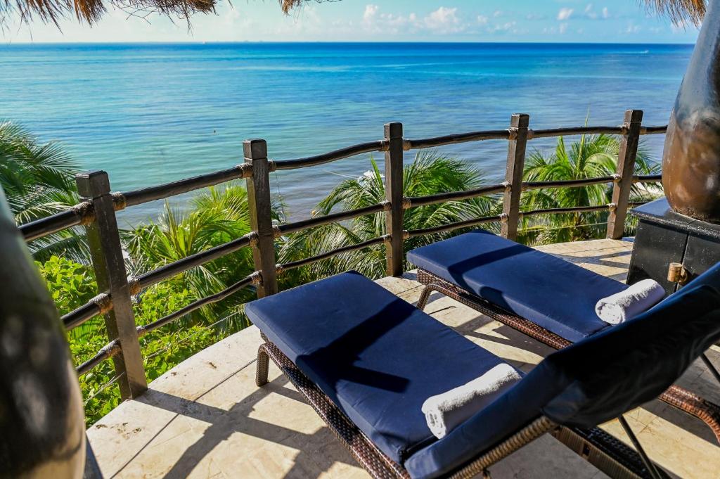 a deck with chairs and the ocean in the background at El Taj Oceanfront and Beachside Condo Hotel in Playa del Carmen