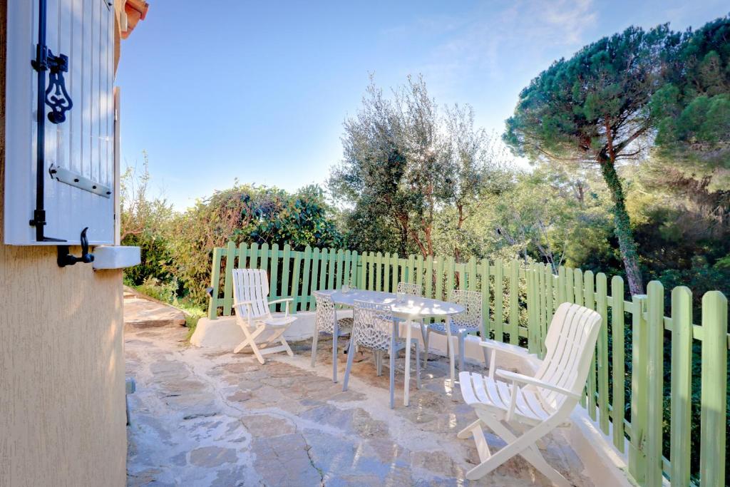 patio ze stołem, krzesłami i ogrodzeniem w obiekcie Isadora Duncan w mieście Rayol-Canadel-sur-Mer