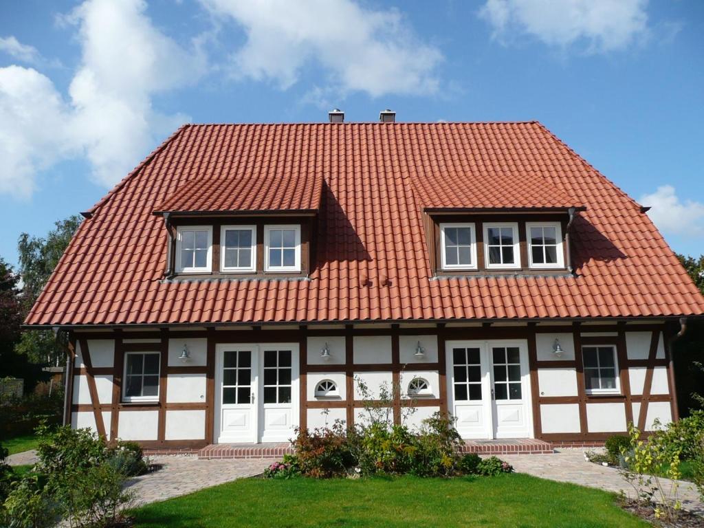a house with an orange roof and white doors at Ferienhaus Mohnblume in Krienke